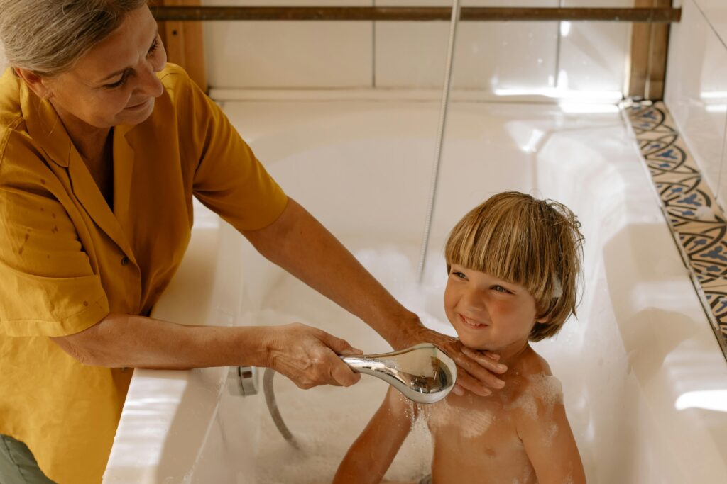 grand-mère-donne-sa-douche-a-petit-enfant-dans-la-baignoire