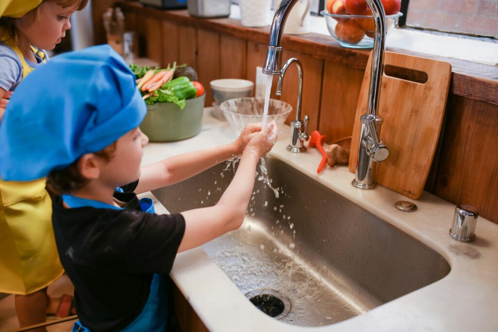 petit-garçon-se-lave-les-mains-près-du-robinet-de-cuisine